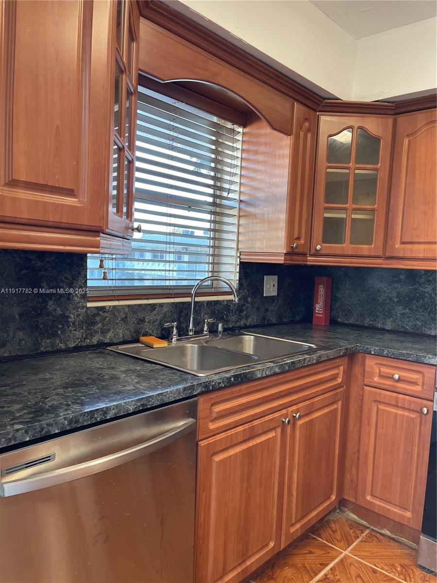 7328 Southwest 82nd Street, Unit B213 Miami, FL 33143 - Photo 8 of 22 a kitchen with stainless steel appliances granite countertop a sink and cabinets