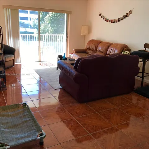 a living room with furniture and a floor to ceiling window
