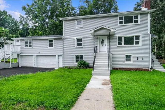 a front view of a house with a garden and plants