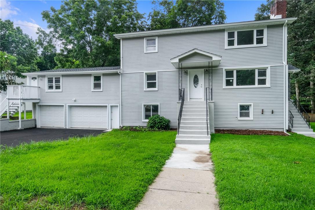 a front view of a house with a garden and plants