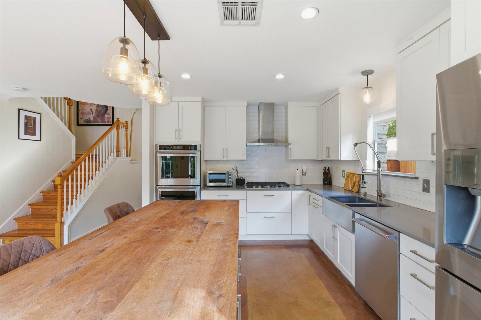 8920 West Hove Loop Austin, TX 78749 - Photo 7 of 39 Modern kitchen featuring white shaker cabinetry, stainless steel appliances including a built-in oven and microwave, and a farmhouse sink