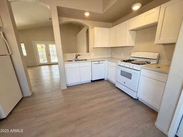 a large kitchen with stainless steel appliances granite countertop a stove a sink and a refrigerator