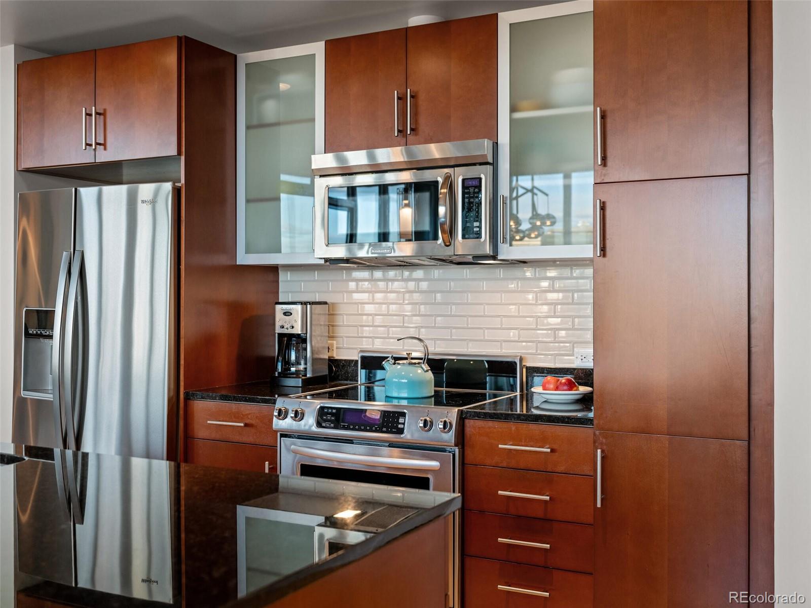 891 14th Street, Unit 4109 Denver, CO 80202 - Photo 14 of 50 a kitchen with stainless steel appliances granite countertop a refrigerator and a stove top oven