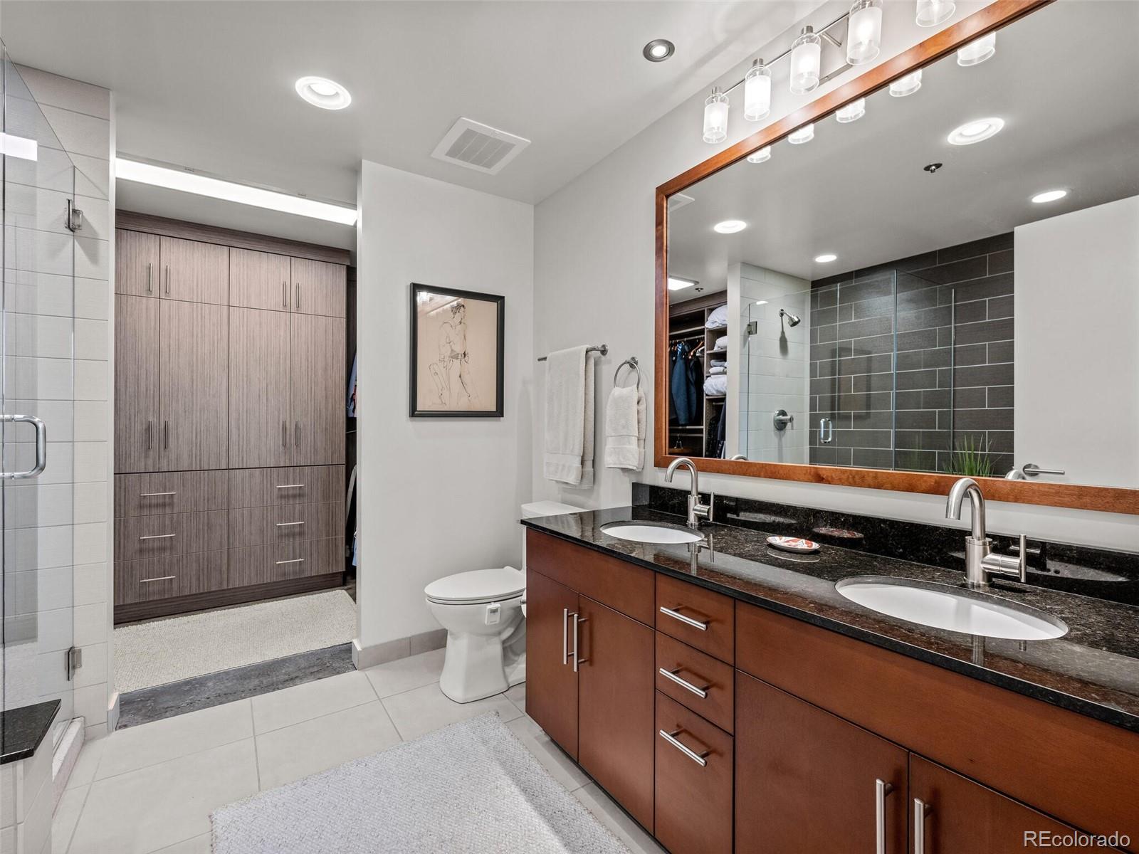 891 14th Street, Unit 4109 Denver, CO 80202 - Photo 19 of 50 a bathroom with double vanity sinks double vanity shower and a mirror