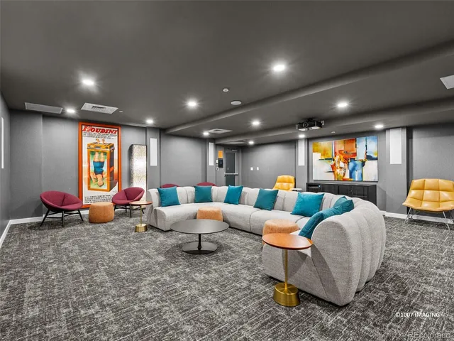 a living room with couches and kitchen view with wooden floor