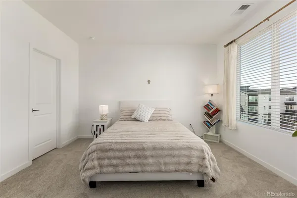 a bedroom with a bed and a large window