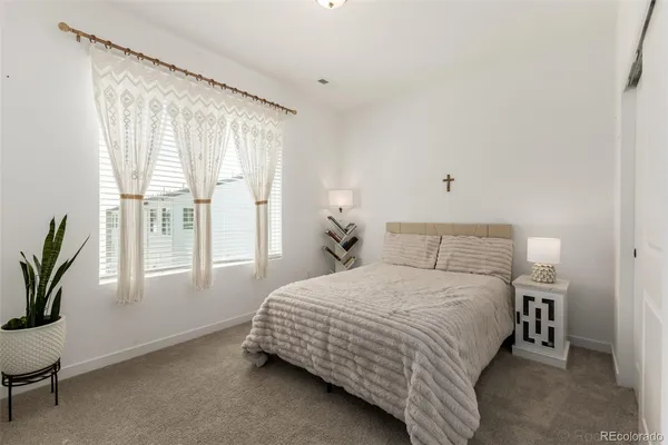 a bedroom with a bed lamp and a window