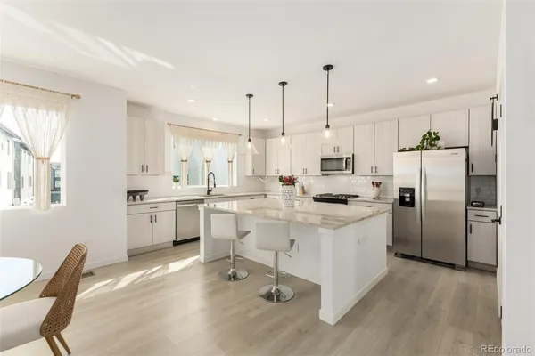 a kitchen with white cabinets and stainless steel appliances