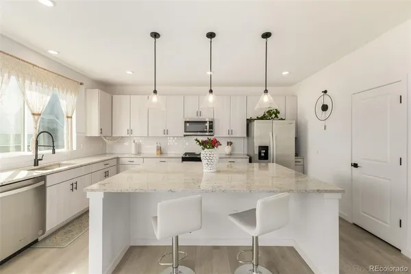 a kitchen with stainless steel appliances kitchen island granite countertop a sink a center island and cabinets