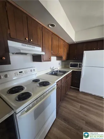 a kitchen with a stove sink and cabinets