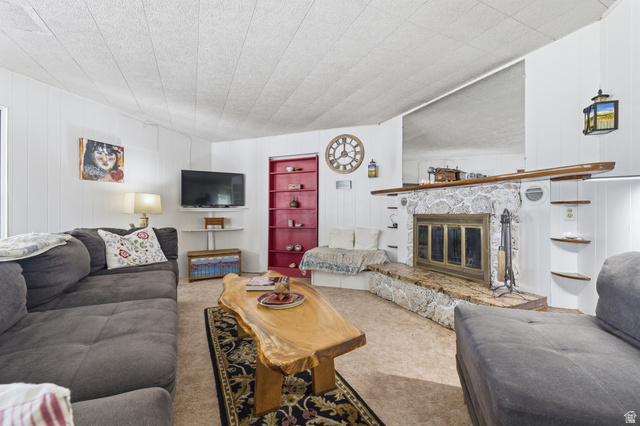 365 North Main Street Fillmore, UT 84631 - Photo 43 of 51 Living area featuring a stone-clad fireplace with a brass firebox, a built-in hearth bench, and a unique wood mantel