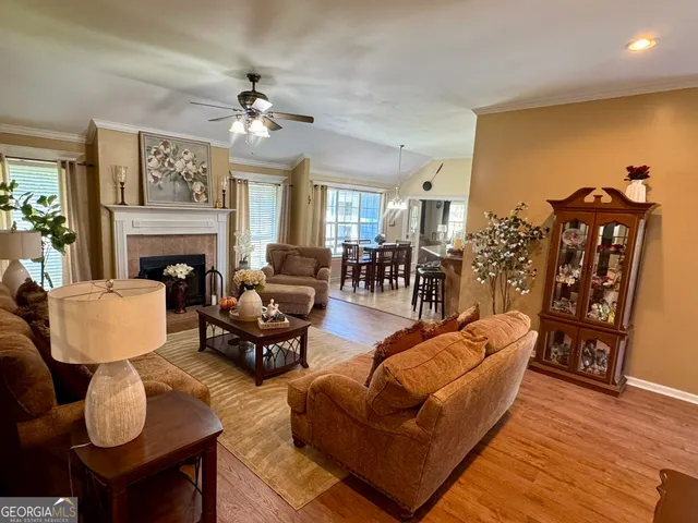 a living room with furniture kitchen view and a fireplace
