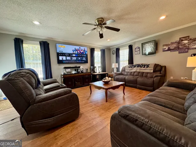 a living room with furniture a large window and a flat screen tv