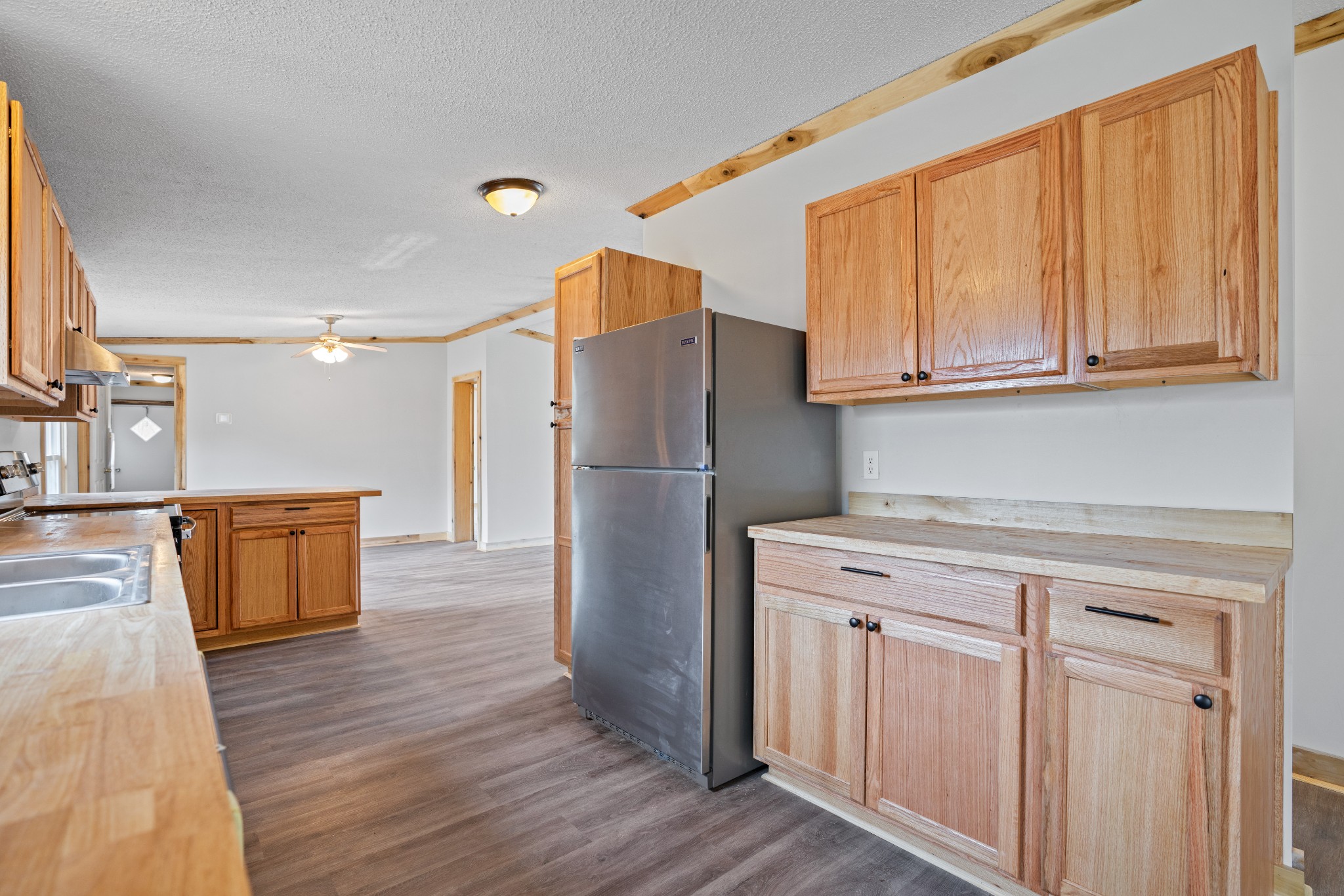4227 Old Metal Road Palmyra, TN 37142 - Photo 6 of 16 a kitchen with stainless steel appliances granite countertop a refrigerator a sink dishwasher and wooden cabinets with wooden floor