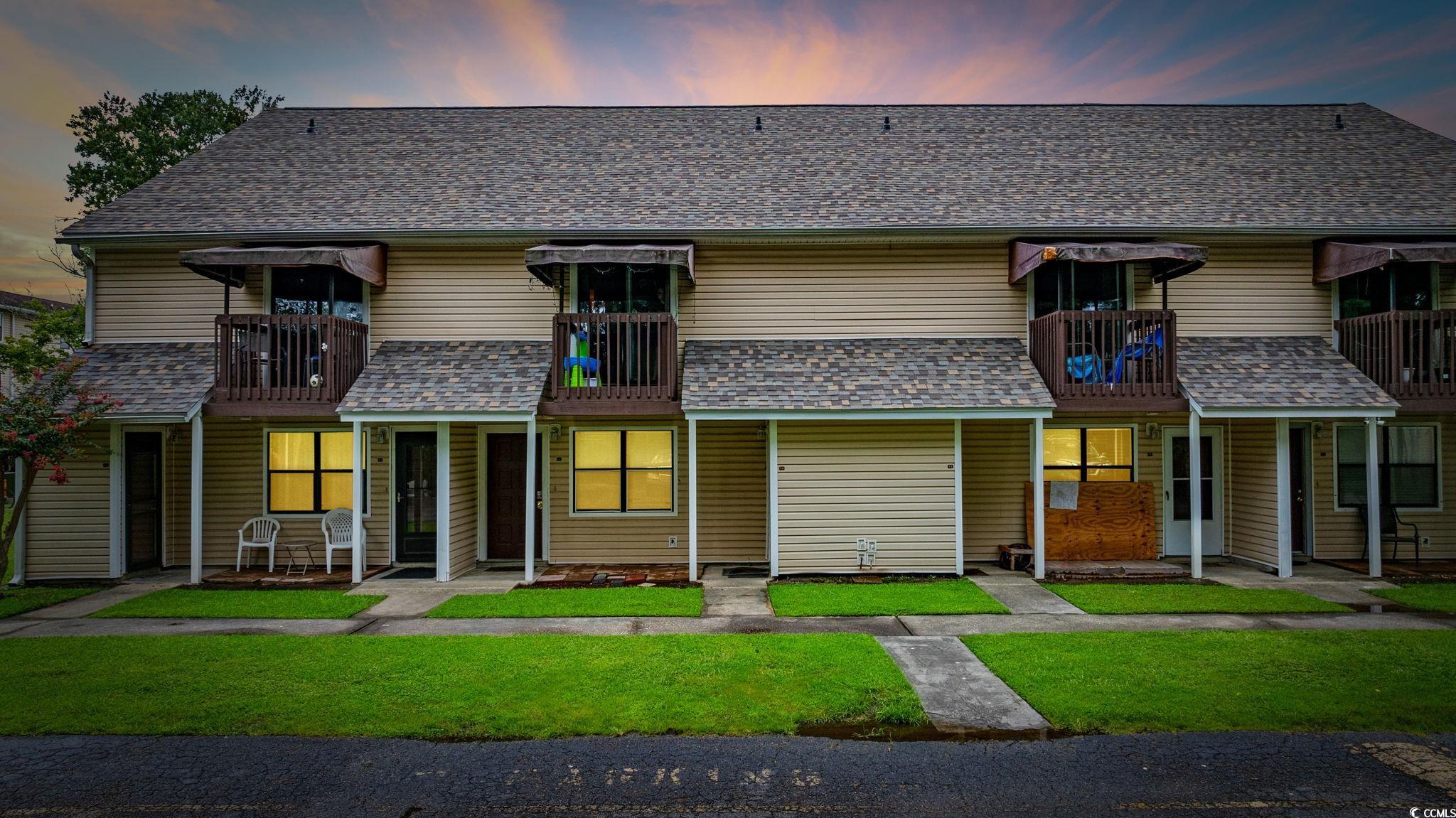 755 Burcale Road, Unit F4 Myrtle Beach, SC 29579 - Photo 1 of 30 View of front of house featuring a balcony, a yard, and a shingled roof
