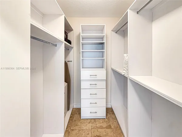 a view of walk in closet with empty racks