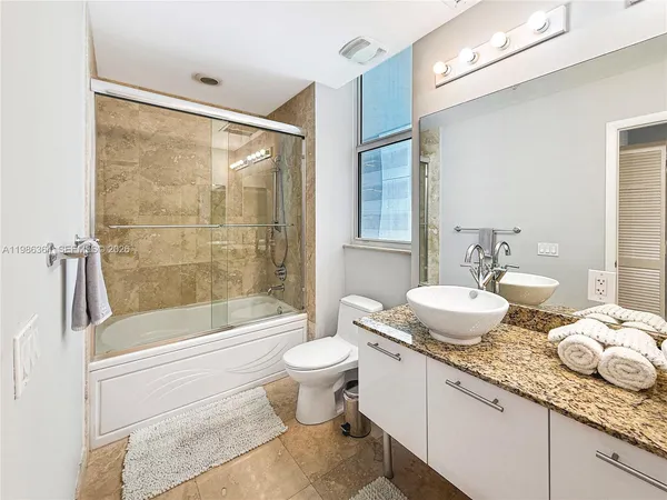 a bathroom with a granite countertop sink toilet and shower