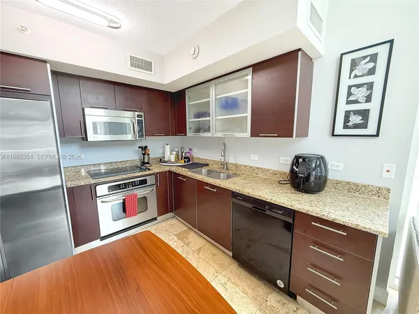 a kitchen with stainless steel appliances granite countertop a sink stove and cabinets