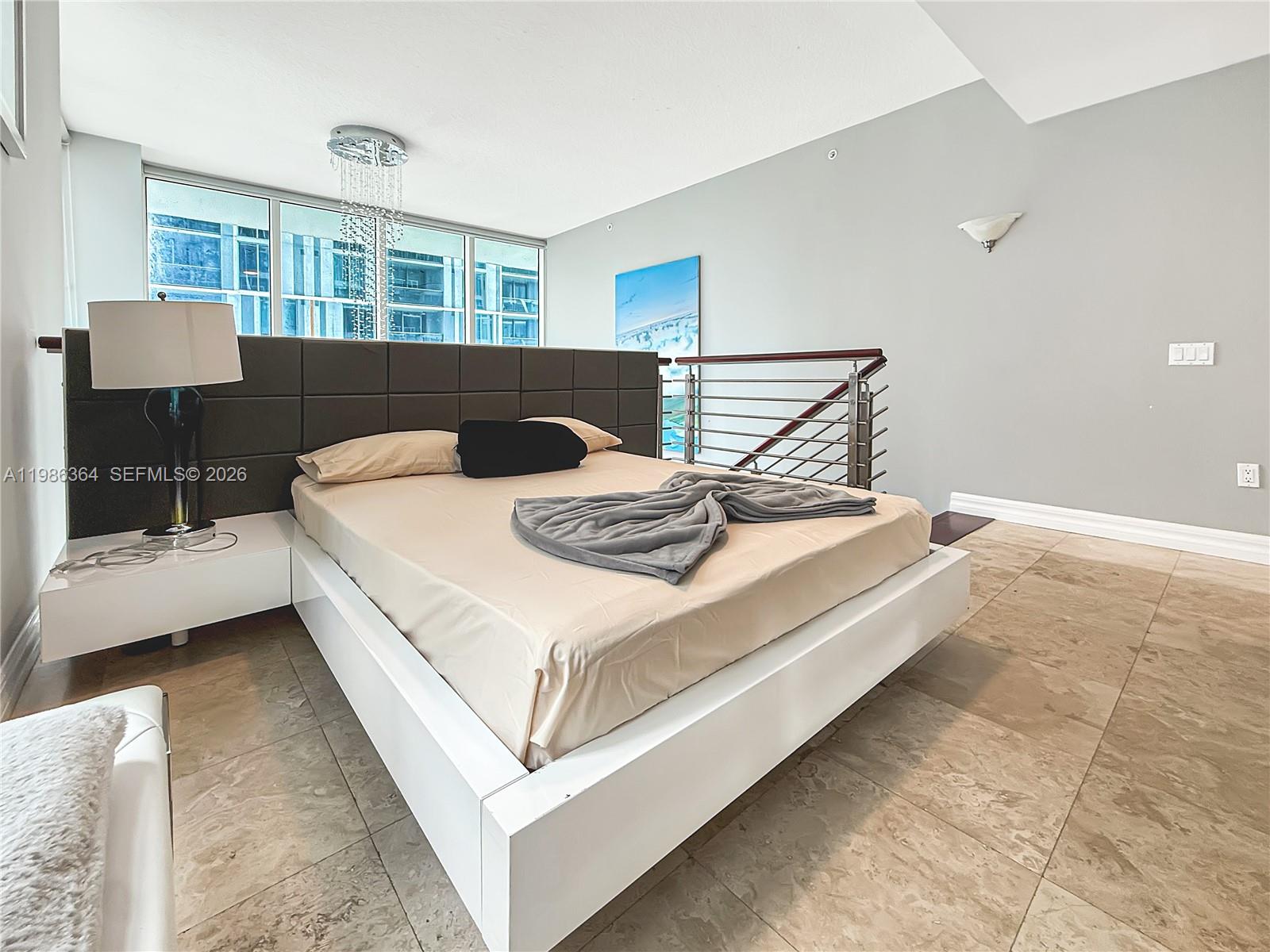 41 Southeast 5th Street, Unit 602 Miami, FL 33131 - Photo 8 of 43 a bedroom with a bed and a window