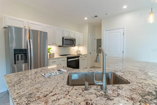 a bathroom with a granite countertop sink a large mirror and a vanity