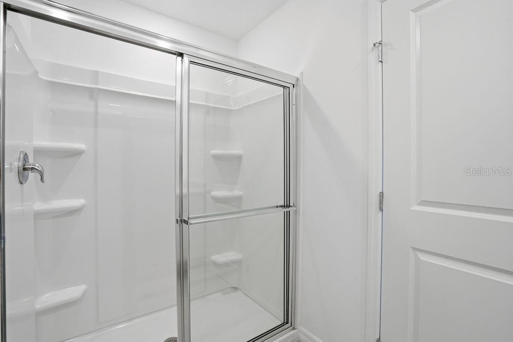 13243 Commons Avenue Parrish, FL 34219 - Photo 15 of 44 a bathroom with a glass shower door