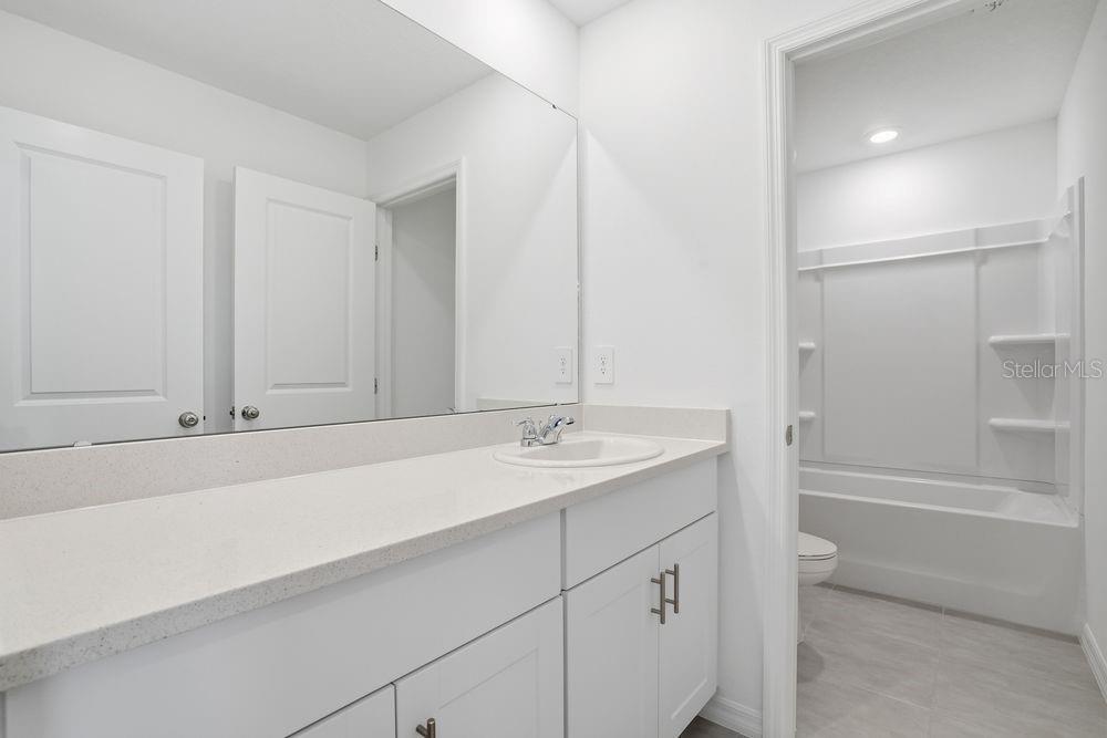 13243 Commons Avenue Parrish, FL 34219 - Photo 25 of 44 a bathroom with a granite countertop sink and mirror with bathtub