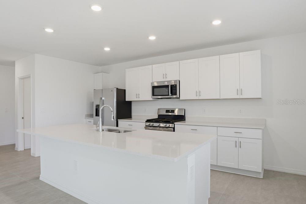 13243 Commons Avenue Parrish, FL 34219 - Photo 4 of 44 a kitchen with white cabinets and stainless steel appliances