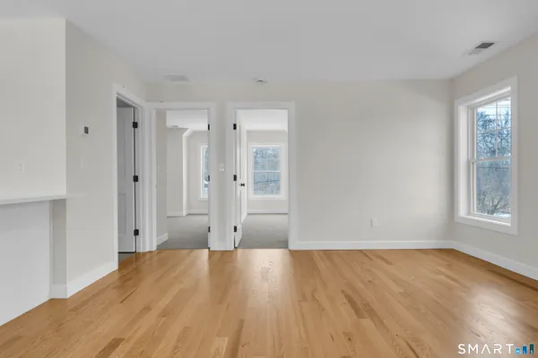 a view of a room with wooden floor and windows