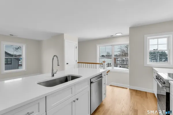a kitchen with counter top space and wooden floor
