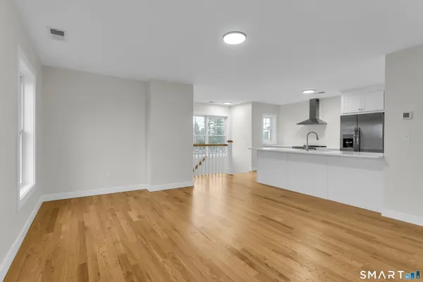 a view of large kitchen with wooden floor and windows