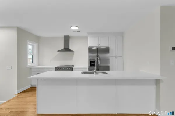 a kitchen with stainless steel appliances a sink stove and cabinets