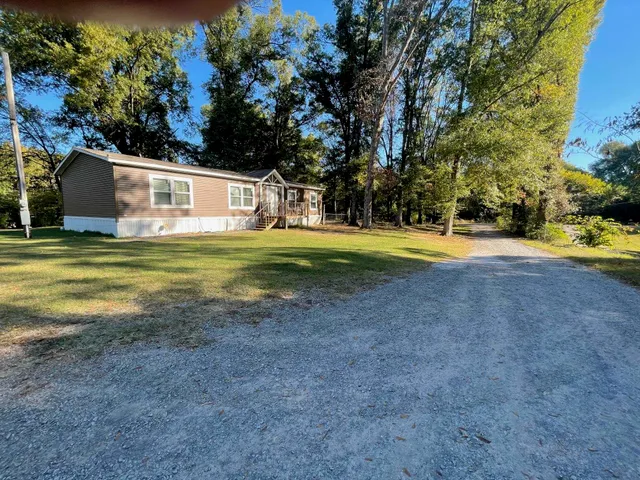 a view of a house with a yard and sitting area