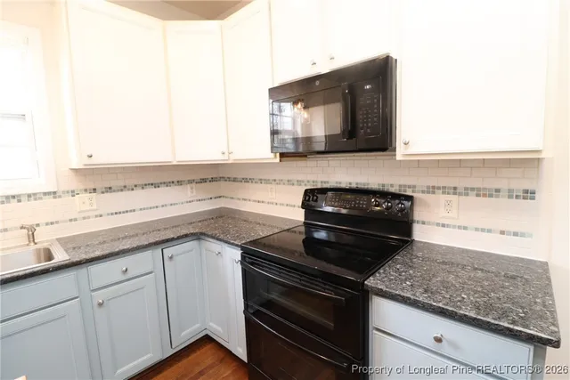 a kitchen with stainless steel appliances granite countertop a sink and a stove