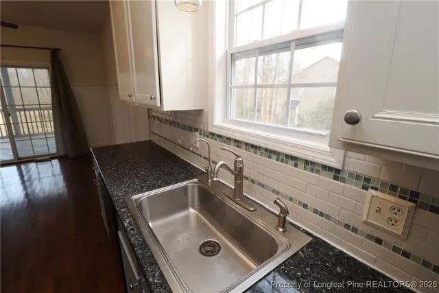 a hall with wooden floor and a sink