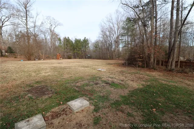 an empty room with windows and chandelier fan