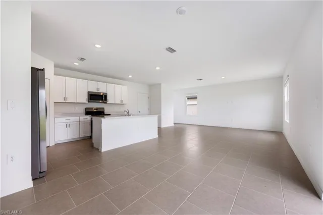 a view of kitchen refrigerator and microwave
