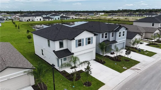 an aerial view of a house with a garden and lake view