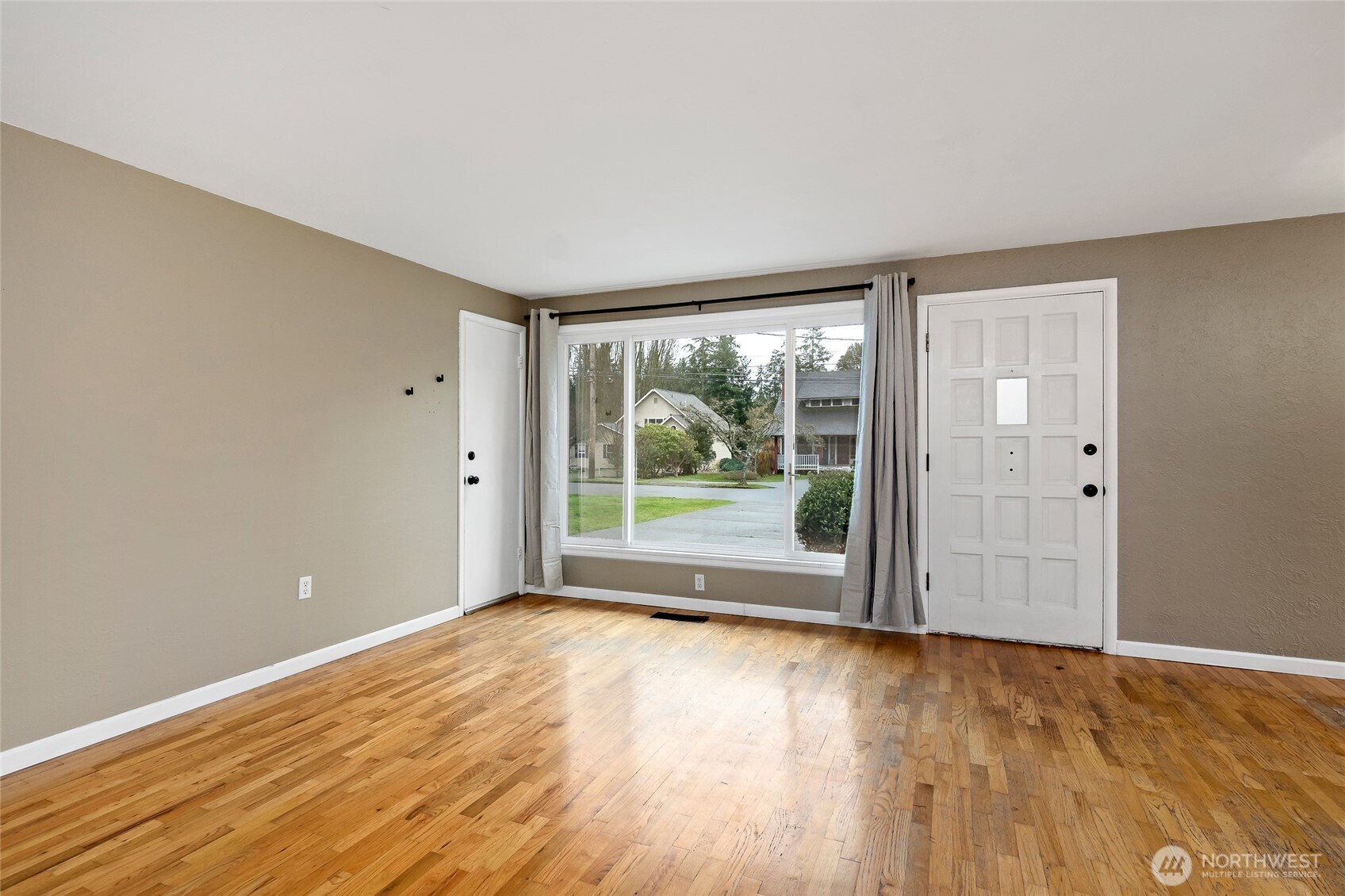 527 Ramsdell Street Fircrest, WA 98466 - Photo 4 of 40 a view of an empty room with wooden floor and a window