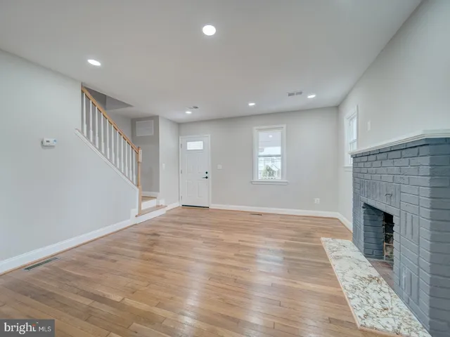 an empty room with windows and fireplace
