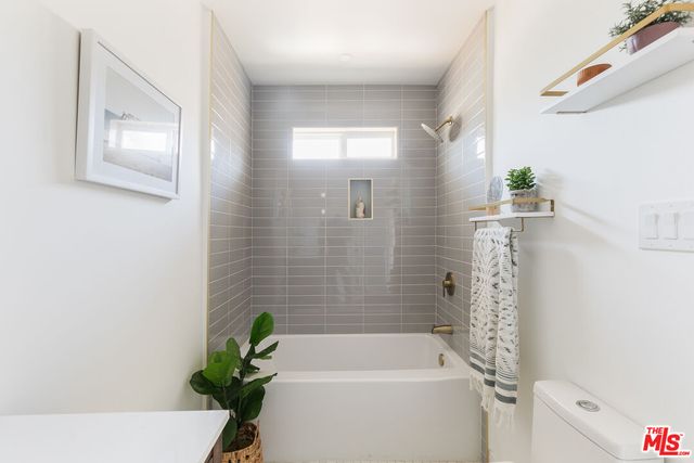 a bathroom with a bathtub a sink a toilet and shower