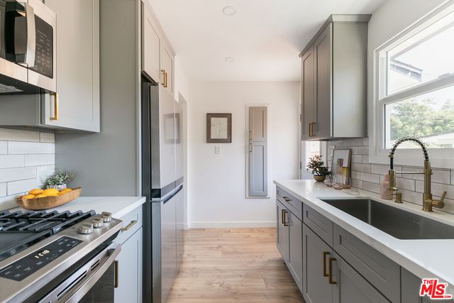 a kitchen with stainless steel appliances granite countertop a stove and a sink