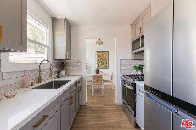 a kitchen with stainless steel appliances granite countertop a sink stove and refrigerator