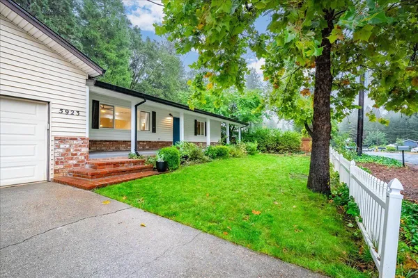a view of a house with backyard and a tree