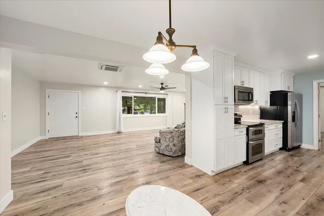 a view of a kitchen with flat screen tv and stainless steel appliances
