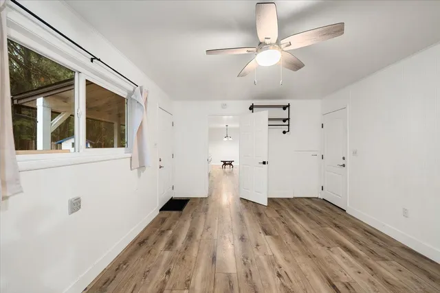 a view of a room with wooden floor and ceiling fan