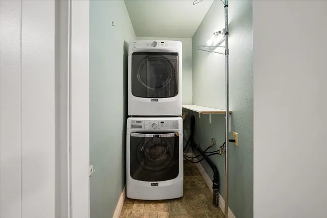 a utility room with wooden floor and washer
