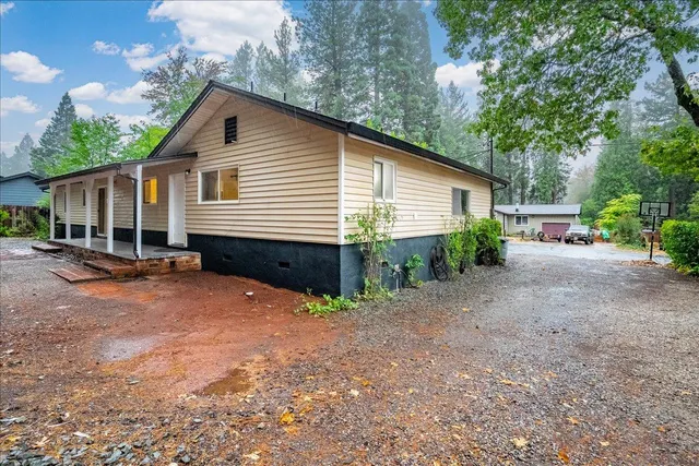 a view of a house with a yard and floor to ceiling window