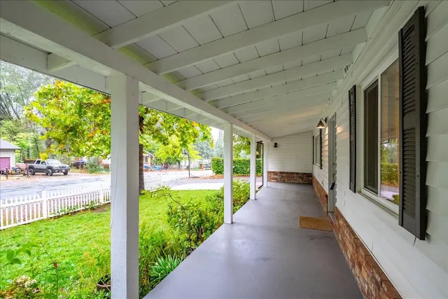 a view of a porch with wooden floor and wooden fence