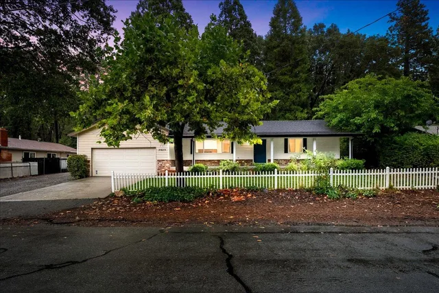a view of a house with a yard and large tree
