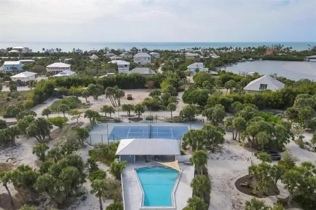 an aerial view of a house with a yard and lake view